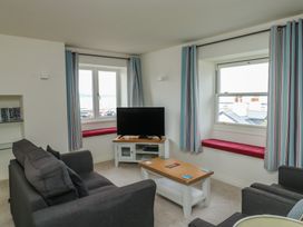 A living room with a television and a coffee table at Bay View in Brixham