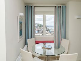A dining room with a round table and a window view at Bay View in Brixham