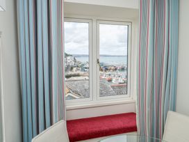 A window with curtains and a seating area at Bay View in Brixham