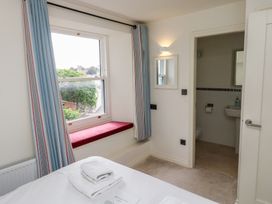A bedroom with a window, bed, and door to bathroom at Bay View in Brixham