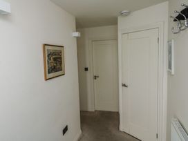 A hallway with a picture on the wall and doors at Bay View in Brixham