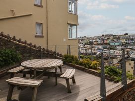 A wooden table and bench seats on a patio at Bay View in Brixham
