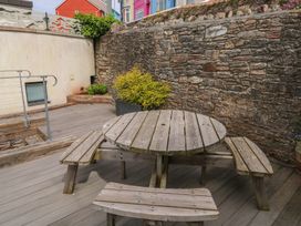 An outdoor area with a wooden table and benches at Bay View in Brixham