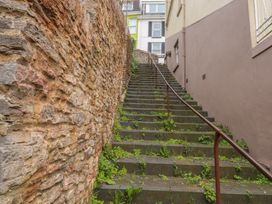 A set of stairs with a stone wall and plants at Bay View in Brixham