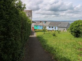 A pathway leading to houses with grass and hedges at Bay View in Brixham