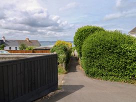 A pathway between hedges with houses in the background at Bay View in Brixham