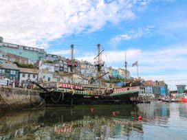 A ship docked in a harbor with buildings in the background at Bay View Brixham