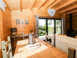 A dining area with wooden furniture and views to the outdoor space at Howgills Retreat Gatebeck near Kirkby Lonsdale
