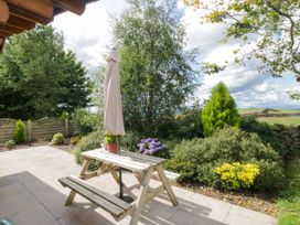 A garden with a table and umbrella at Howgills Retreat Gatebeck near Kirkby Lonsdale