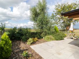 A garden with a patio, table and chairs at Howgills Retreat in Gatebeck near Kirkby Lonsdale