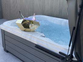 A hot tub with champagne and glasses at Ninky Nonk in Bishop Sutton