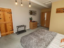 A bedroom with a bed, wardrobe, and a plant at Country Retreat in Ponteland