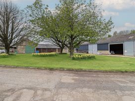 An outdoor area with a tree and buildings at Country Retreat in Ponteland