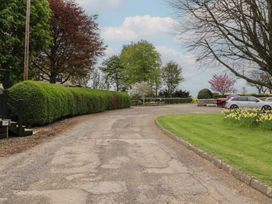 A driveway with landscaped bushes and trees at Country Retreat in Ponteland