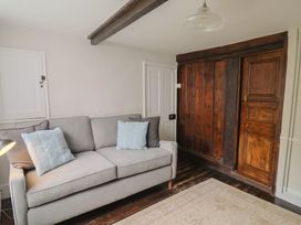 A living room with a sofa and wooden cabinet at The Nest in Lyme Regis