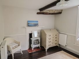 A bedroom with a fireplace and furniture at The Nest Lyme Regis