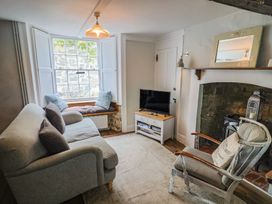 A living room featuring a sofa and television at The Nest in Lyme Regis
