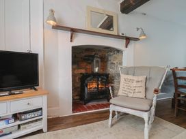 A living room with a television and a fireplace at The Nest in Lyme Regis