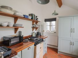 A kitchen with microwave and shelves at The Nest Lyme Regis