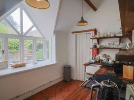 A kitchen with windows, counter, and shelves at The Nest Lyme Regis