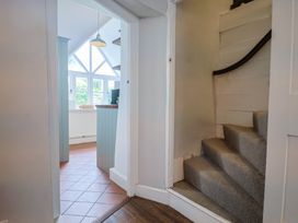 A hallway with stairs leading to an upper level at The Nest in Lyme Regis