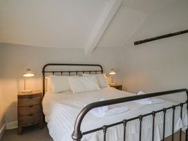 A bedroom with a bed and side tables at The Nest in Lyme Regis