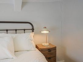 A bedroom with a bed and nightstand at The Nest in Lyme Regis