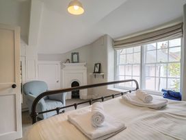A bedroom with a bed and armchair at The Nest in Lyme Regis