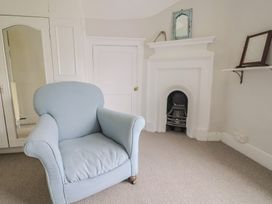 A sitting room with a chair and a fireplace at The Nest in Lyme Regis