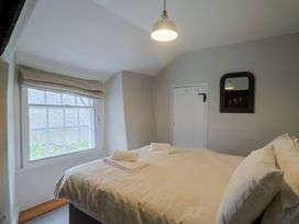 A bedroom with a bed and window at The Nest in Lyme Regis
