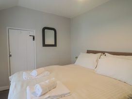 A bedroom with a bed and towels at The Nest in Lyme Regis