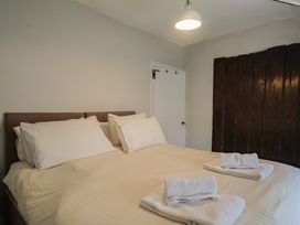 A bedroom with a bed and towels at The Nest in Lyme Regis