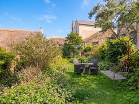 A garden with a table and chairs at The Nest in Lyme Regis