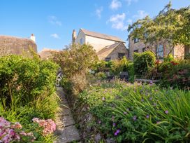 A garden with a pathway surrounded by flowers at The Nest in Lyme Regis