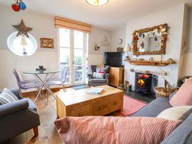 A living room with a sofa, coffee table, and television at Seaside in Lyme Regis