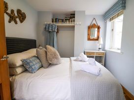 A bedroom with a bed and shelving at Seaside in Lyme Regis