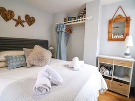 A bedroom with a bed and books on a shelf at Seaside in Lyme Regis