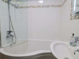 A bathroom with a bathtub and shower at Seaside in Lyme Regis