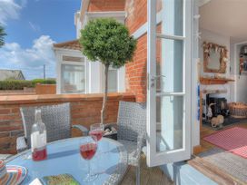 An outdoor seating area with a table and wine glasses at Seaside in Lyme Regis