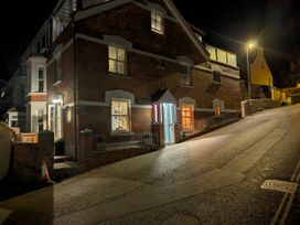 A building at night with illuminated windows and a sloped street at Seaside in Lyme Regis