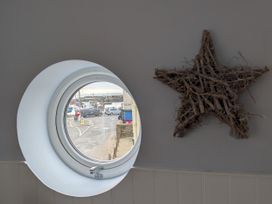 A window view of a street with vehicles and boats at Seaside Lyme Regis
