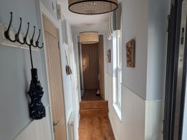 A hallway with coat hooks and a door at Seaside in Lyme Regis