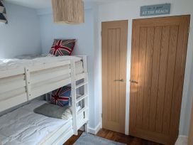 A bedroom with a bunk bed and doors at Seaside in Lyme Regis