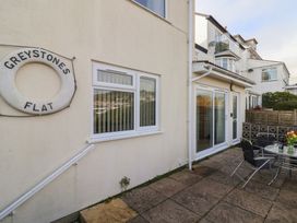 An outdoor area with seating and a sign at Greystones Flat in Lyme Regis
