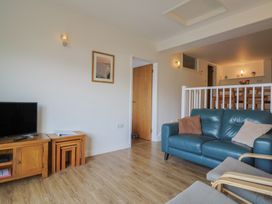 A living room with a sofa and television at Greystones Flat in Lyme Regis