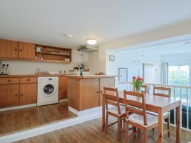 A kitchen and dining area with wooden furniture at Greystones Flat in Lyme Regis
