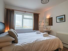 A bedroom with a bed and sink at Greystones Flat Lyme Regis