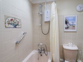 A bathroom with a bathtub and toilet at Blacksmiths Cottage in Lyme Regis