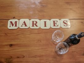 Coasters spelling Maries with glasses and a wine bottle at Maries in Lyme Regis