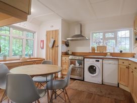 A kitchen with a round table and appliances at Maries in Lyme Regis